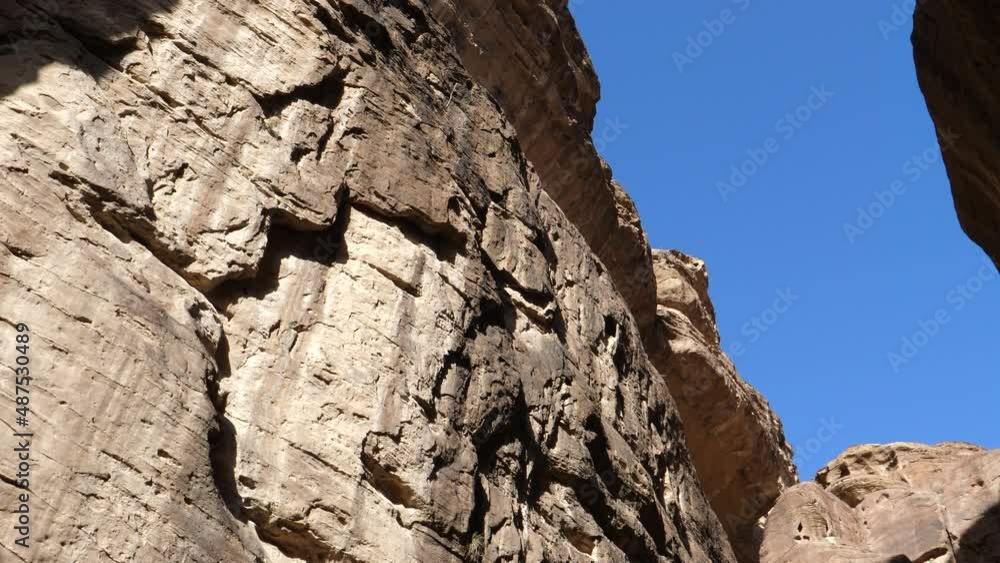 Petra Jordan FEBRUARY, 2, 2018: Sunlight entering Siq. The main entrance to the ancient Nabatean city of Petra in southern Jordan. A dim narrow gorge formed through splitting of the mountain. Petra Jordan FEBRUARY, 2, 2018: Sunlight entering Siq. The main entrance to the ancient Nabatean city of Petra in southern Jordan. A dim narrow gorge formed through splitting of the mountain.