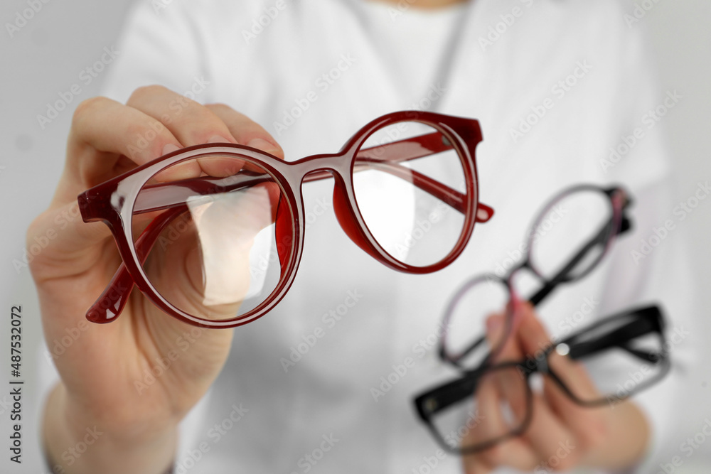 Woman with different glasses on light background, closeup Woman with different glasses on light background, closeup