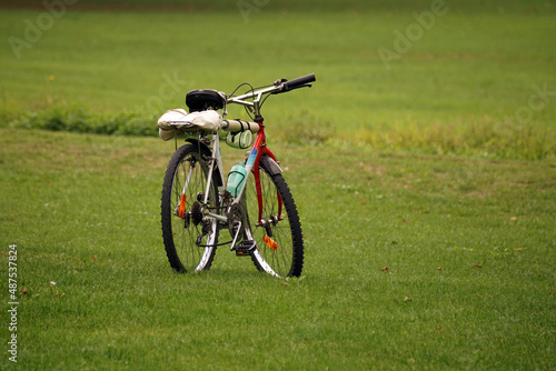 Primo piano di bicicletta appoggiata sul cavalletto e parcheggiata su prato verde in estate