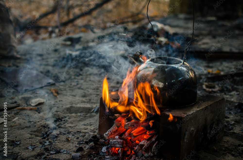 A picnic kettle on a bonfire close-up. Campaign tourism background A picnic kettle on a bonfire close-up. Campaign tourism background
