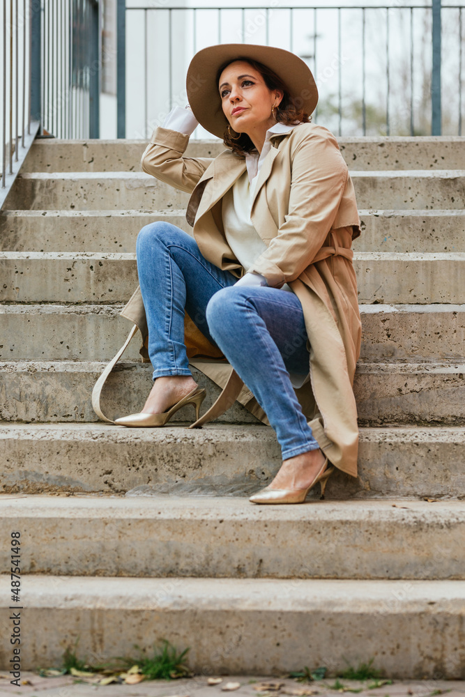 Thoughtful woman thinking about something while sitting on the stairs in the street. Thoughtful woman thinking about something while sitting on the stairs in the street.