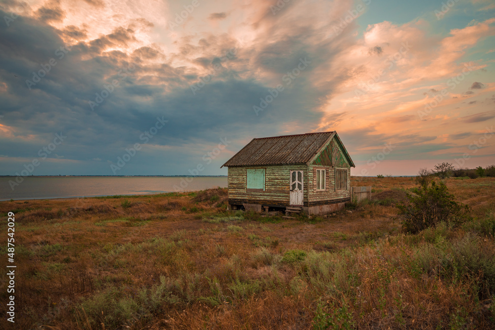 Abandoned small country house in the middle of the meadow near the lake Abandoned small country house in the middle of the meadow near the lake