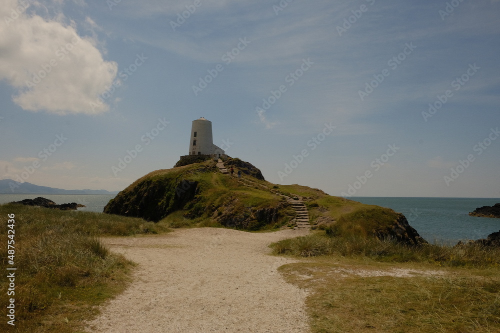 Old lighthouse in Anglesey with sand and greenery