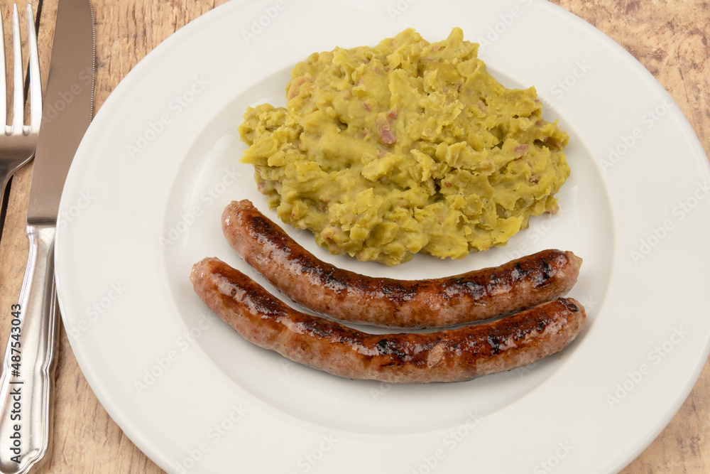 mashed split peas on a plate with fresh sausages