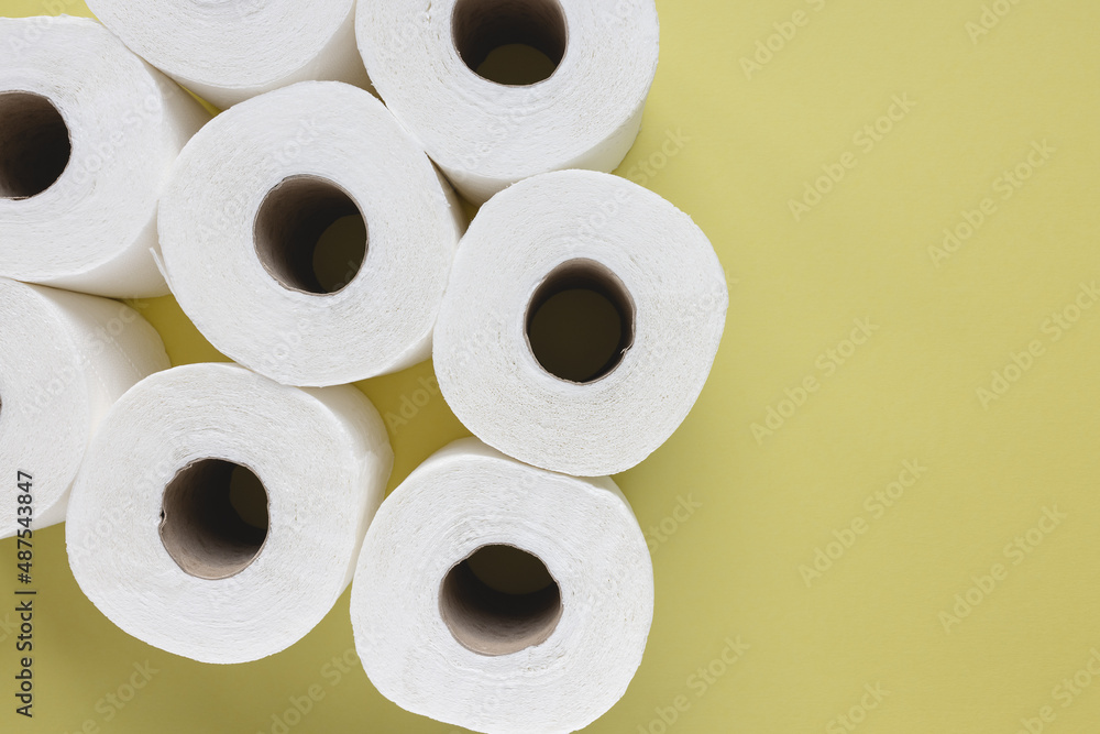 Fresh new white toilet paper rolls on yellow background. Personal hygiene and health issues concept. Top view, copy space Fresh new white toilet paper rolls on yellow background. Personal hygiene and health issues concept. Top view, copy space