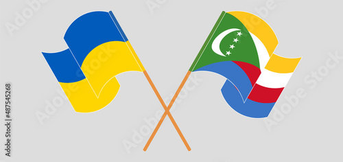 Crossed and waving flags of Ukraine and Comoros
