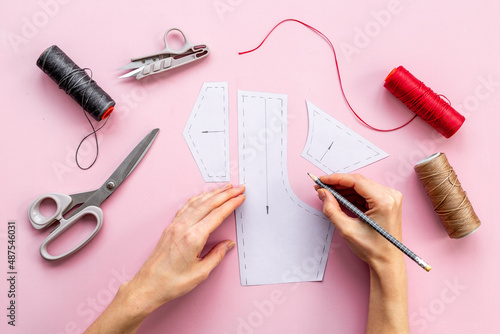 Female hands holding sewing patterns. Sewing background for dress workshop photo