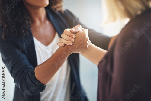 Hand in hand in the journey of success. Cropped shot of two businesswomen shaking hands in solidarity at work.