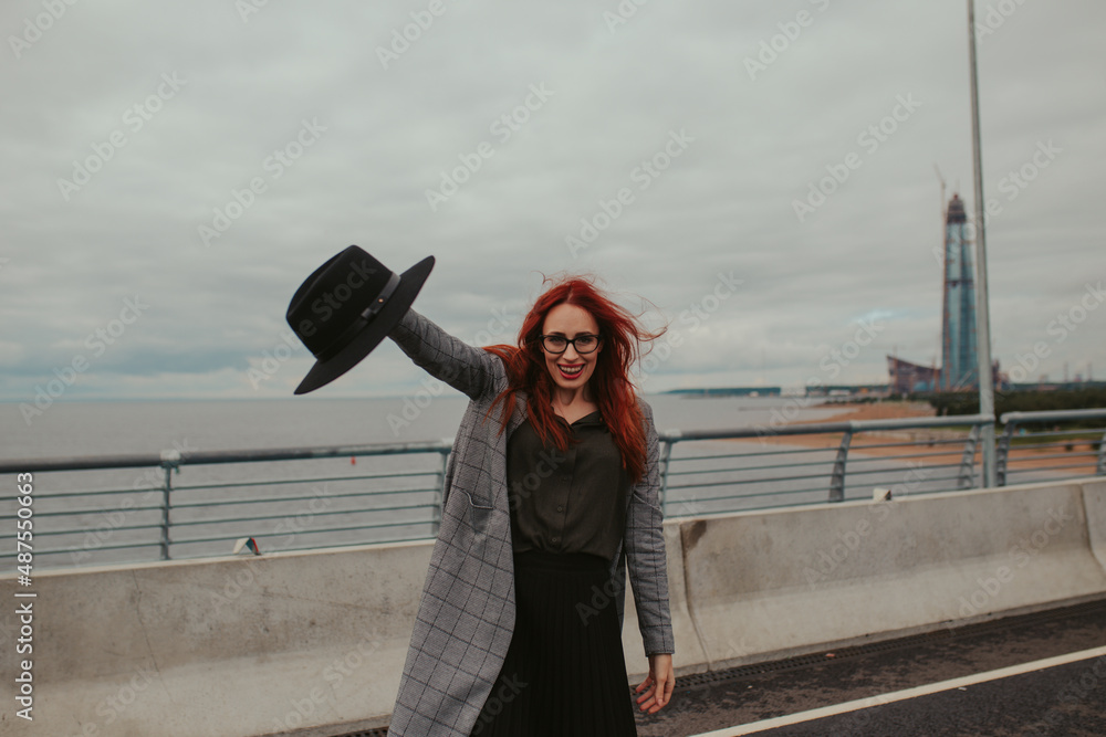 young woman with red hair laughing with braces