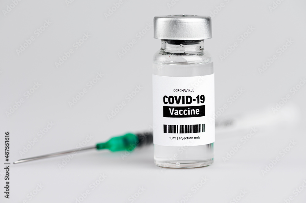 A vial glass bottle of COVID-19 vaccine. SARS - CoV2 vaccination concept. Vaccine against coronavirus. Green needle. 