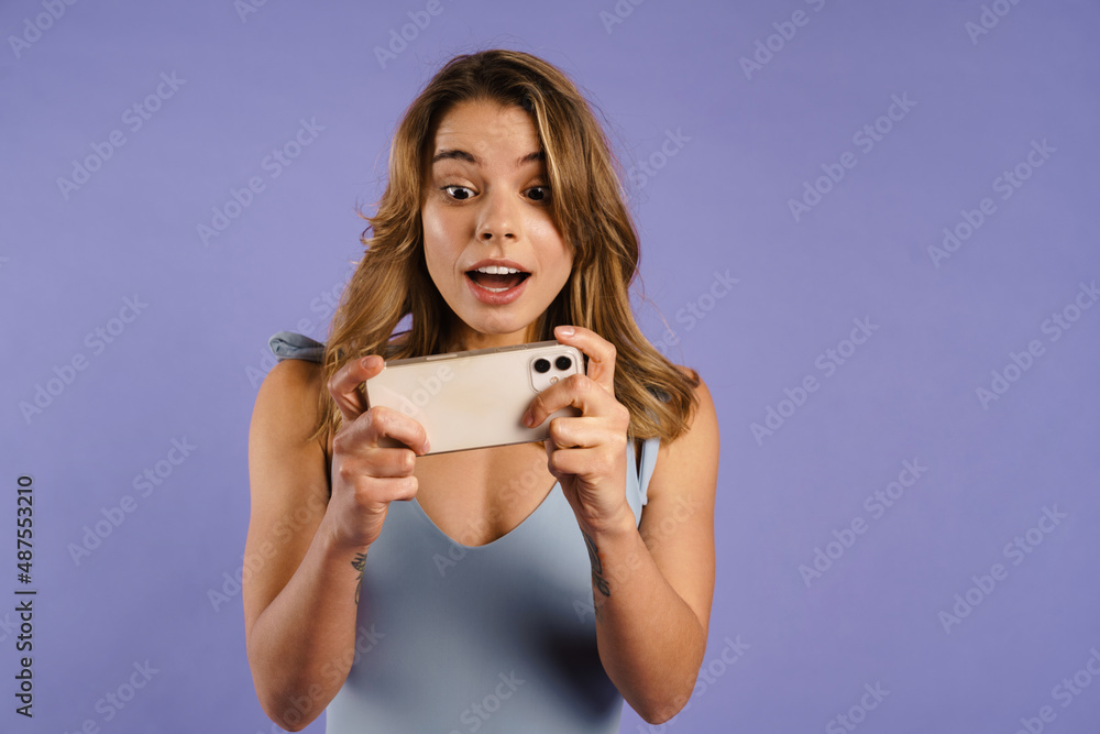 Young white woman rejoicing and holding cellphone Young white woman rejoicing and holding cellphone