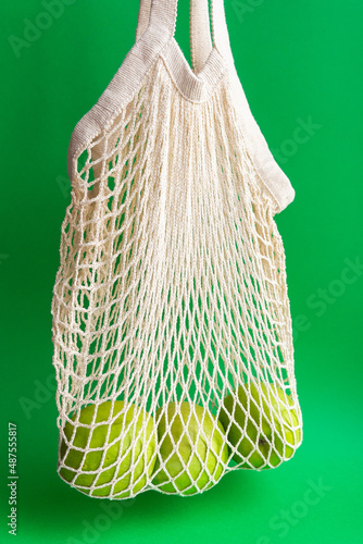 Fresh green apples in a mesh bag. Healthy food, eco-friendly packaging. Waste recycling. Zero  waste.