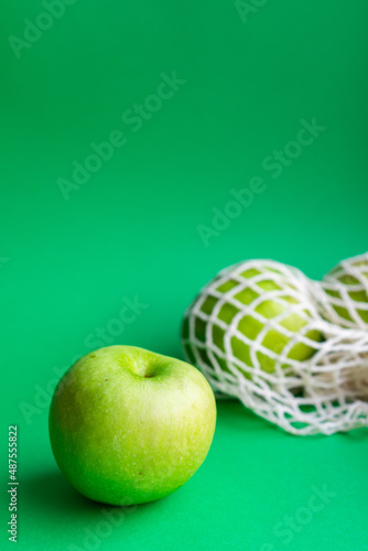 Fresh green apples in a mesh bag. Healthy food, eco-friendly packaging. Waste recycling. Zero  waste.