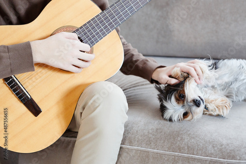 Handsome young guy hold acoustic instrumental guitar playing song