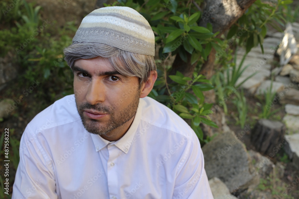 Man wearing traditional skullcap with revengeful expression