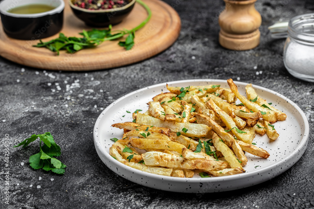 Oven roasted parsnips side dish on plate. Delicious vegetarian breakfast or snack, Clean eating, dieting, vegan food concept. top view Oven roasted parsnips side dish on plate. Delicious vegetarian breakfast or snack, Clean eating, dieting, vegan food concept. top view
