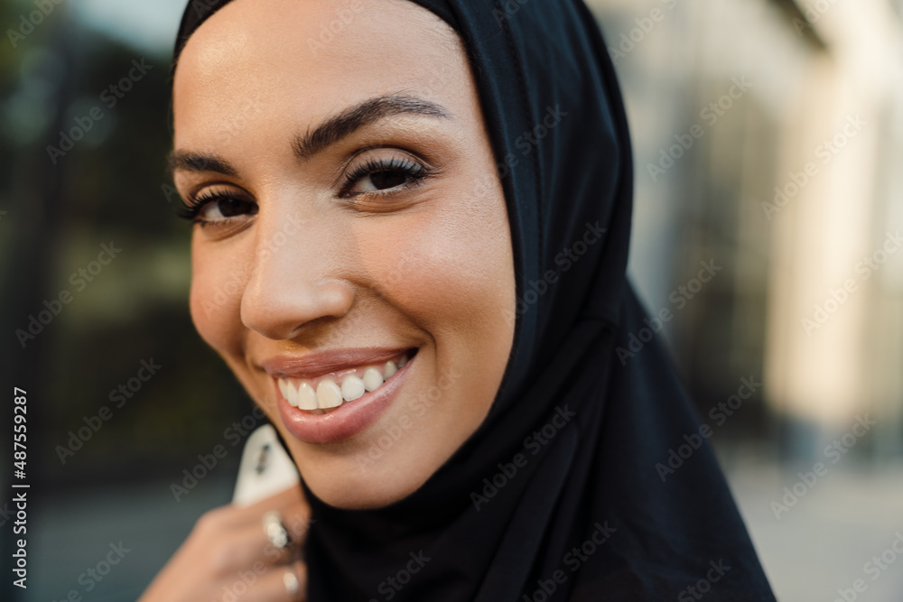 White muslim woman dressed in hijab smiling and looking at camera Stock  Photo | Adobe Stock