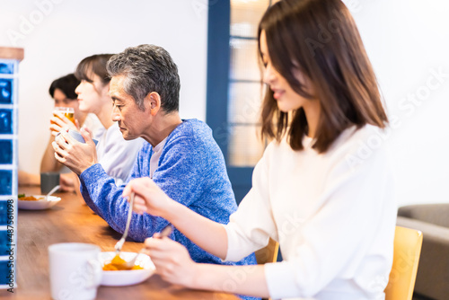 レストランのカウンター席でご飯を食べる人々