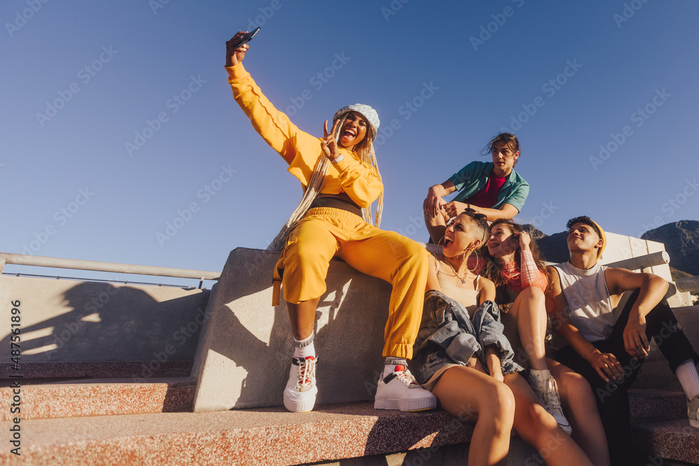 Naklejka premium Vibrant young people taking a selfie together outdoors