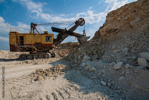 Old excavator loading marl in an open pit. photo