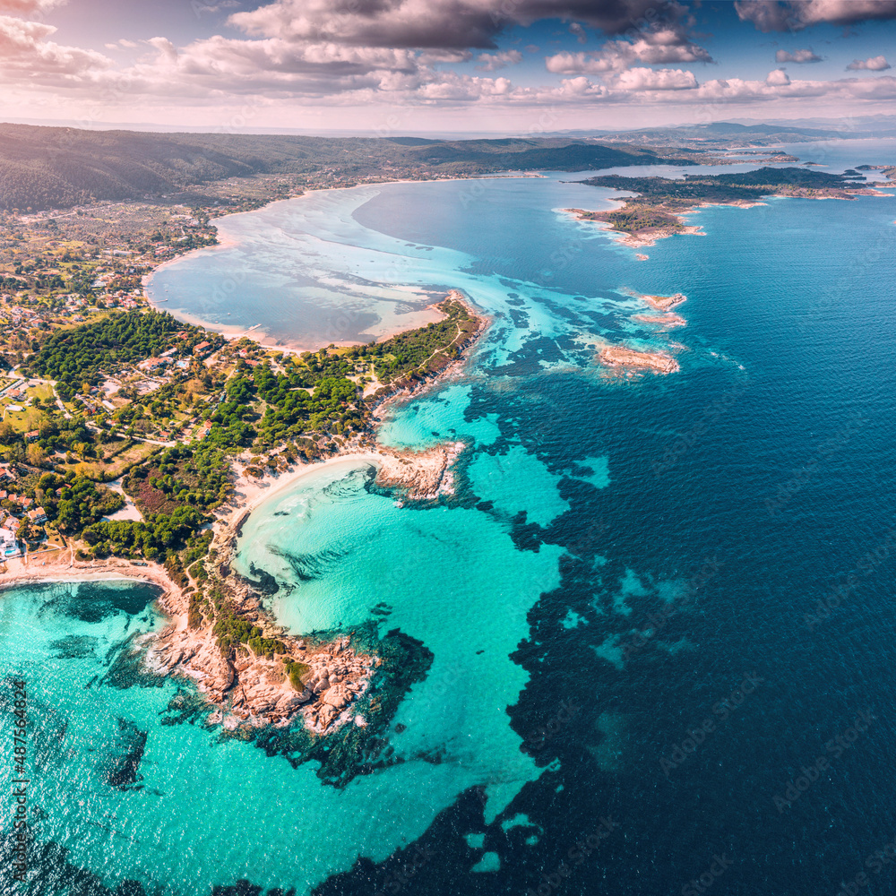 Aerial view of the paradise seashore with various shades of turquoise water. Coral reefs and secluded sandy beaches in the resort village of Vourvourou in Sithonia, Halkidiki.