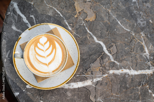Cappuccino white coffee cup with heart shape art. Marble table. Top view. Copy space
