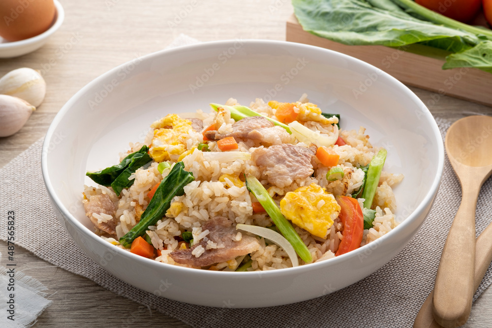 Easy Pork Fried Rice with kale, carrot, egg, onion and tomato in white plate Easy Pork Fried Rice with kale, carrot, egg, onion and tomato in white plate