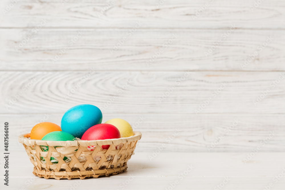 Multi colors Easter eggs in the woven basket on colored background . Pastel color Easter eggs. holiday concept with copy space Multi colors Easter eggs in the woven basket on colored background . Pastel color Easter eggs. holiday concept with copy space