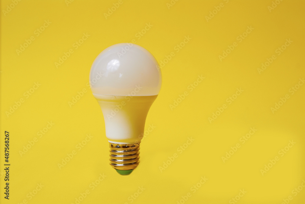 White led light bulb on yellow background White led light bulb on yellow background