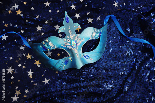 Photo of elegant and delicate Venetian mask over blue dark stars background