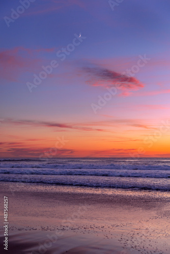 Colourful skies, ocean beach and moon © Bostock