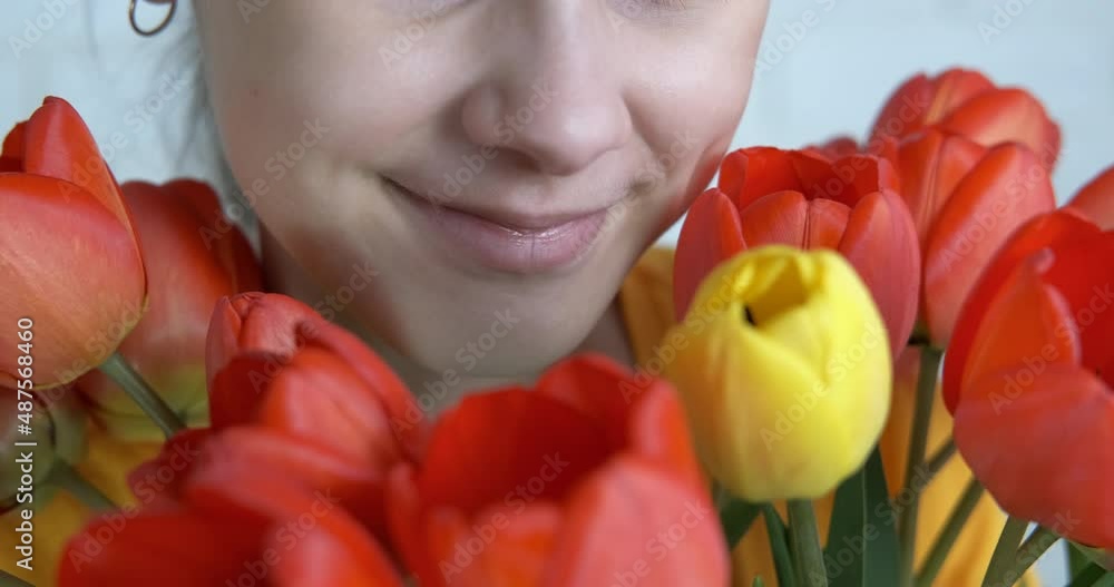 Teenager girl with tulips. Pretty girl smiles looking at flowers. Teenager girl with tulips. Pretty girl smiles looking at flowers.