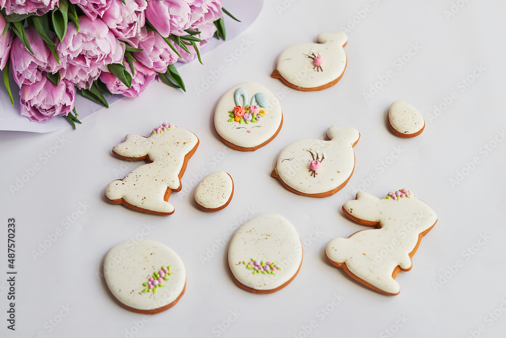Easter composition with sweet bread, gingerbread rabbits and eggs, bouquet of flowers tulip. Holidays breakfast. Traditional easter gingerbread cookies. Easter Greeting Card Template Easter composition with sweet bread, gingerbread rabbits and eggs, bouquet of flowers tulip. Holidays breakfast. Traditional easter gingerbread cookies. Easter Greeting Card Template