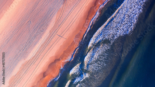 Top down aerial view over surfer walking on beach, Gold Coast Australia