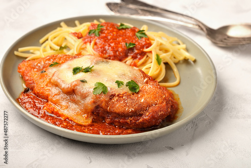 Plate of chicken parmigiana with spaghetti close-up