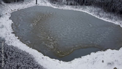 Aerial drone view of a frozen bog lake in winter. Recorded in Alatsi lake, Teringi bog in Estonia. photo