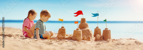 Canvas Print Boy and girl playing on the beach on summer holidays.