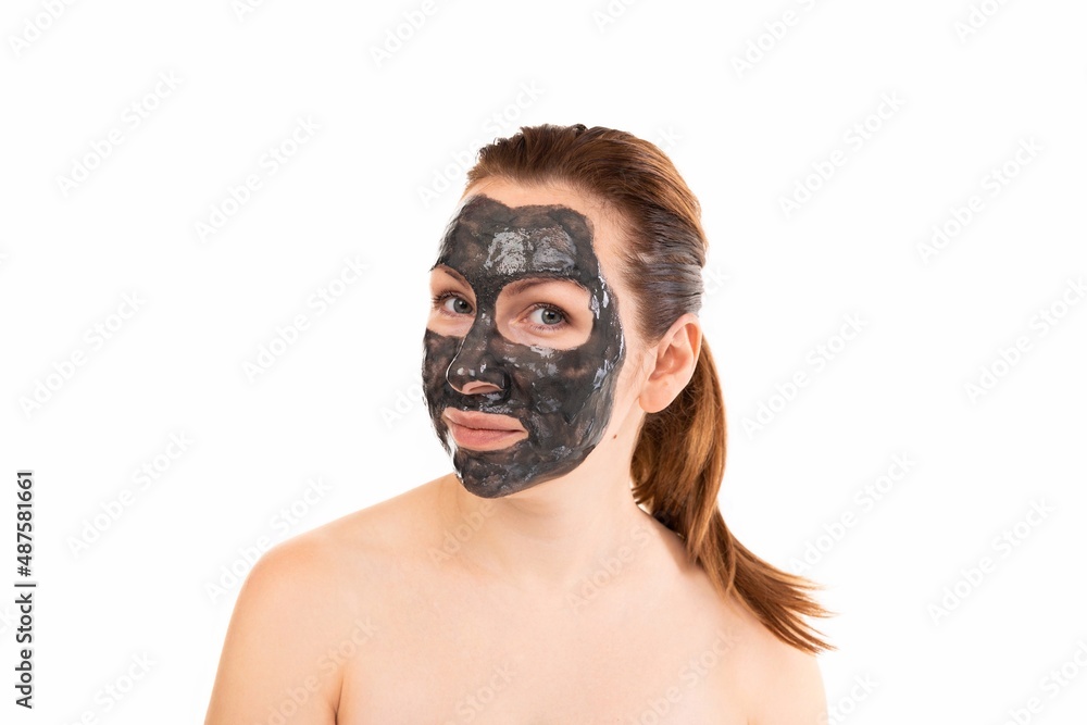 young woman after a shower with a black cosmetic mask on her face made of clay young woman after a shower with a black cosmetic mask on her face made of clay