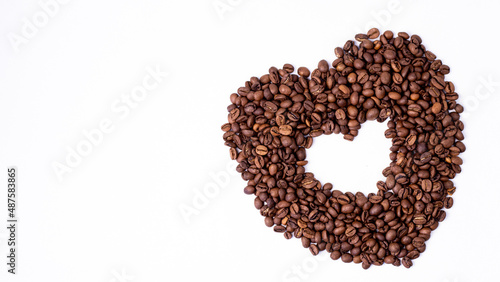 heart of brown fragrant coffee beans lie on a white background for text