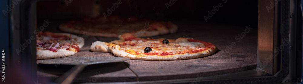 frische italienische Pizza aus dem Ofen in der Hand im Restaurant 