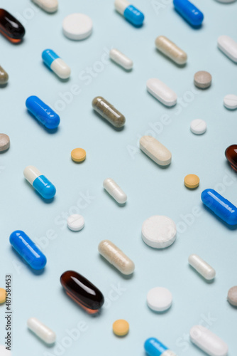 Different pills pattern on blue background. Assorted medicine drugs.
