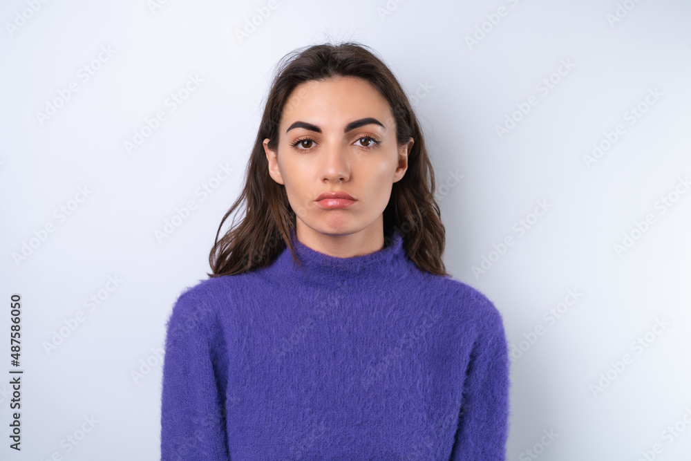 Young woman in purple soft cozy sweater in the background upset Young woman in purple soft cozy sweater in the background upset