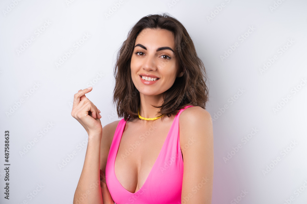 Summer portrait of a young woman in a pink swimsuit, bright yellow beach necklace Summer portrait of a young woman in a pink swimsuit, bright yellow beach necklace