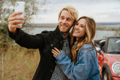 White mid couple taking selfie on cellphone during trip