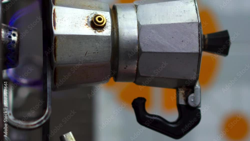Close up of piezoelectric gas lighter turning on gas stove for traditional Italian Neapolitan coffee with moka machine. VERTICAL format Close up of piezoelectric gas lighter turning on gas stove for traditional Italian Neapolitan coffee with moka machine. VERTICAL format