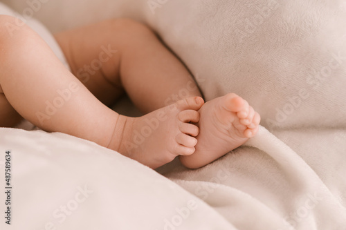 Small legs of a newborn girl on a light background © ksyusha_yanovich