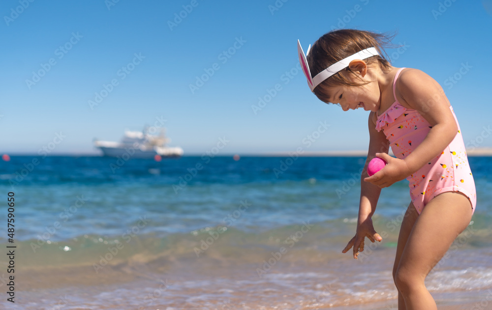 Cute girl with bunny hairband holding colorful eggs in her hands, hunting for the eggs. Happy Easter holidays concept. Copy space Cute girl with bunny hairband holding colorful eggs in her hands, hunting for the eggs. Happy Easter holidays concept. Copy space