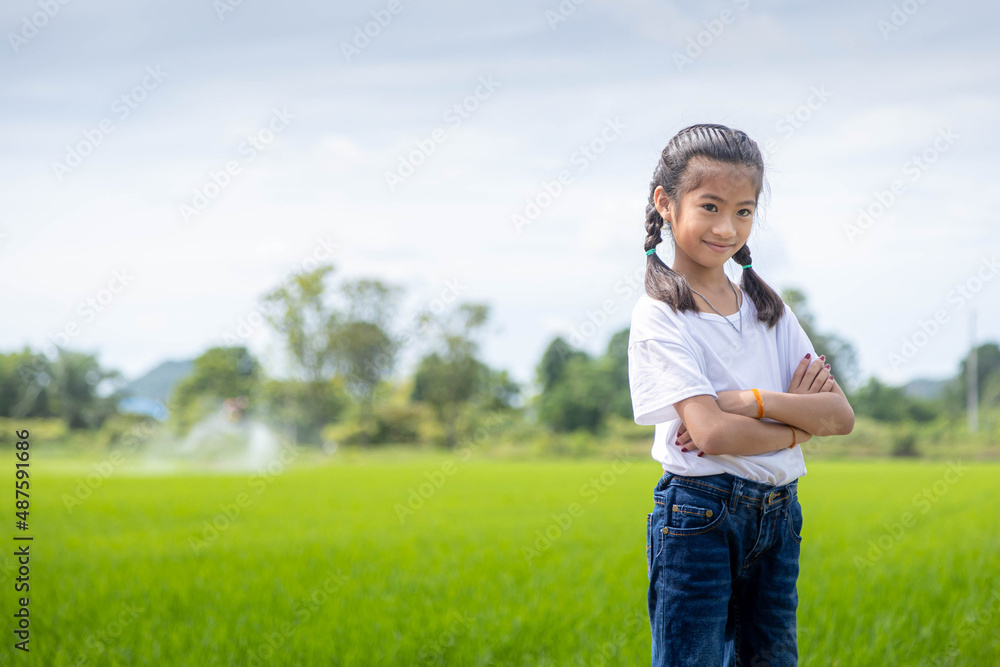 An Asian girl studying rice cultivation at rice field. Agricultural development and smart technology concept.