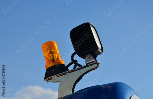 the beacon on the machine flashes orange warning color. everyone around will notice the unusually large load and avoid an accident or injury to the construction site workers. halogen with led lights photo