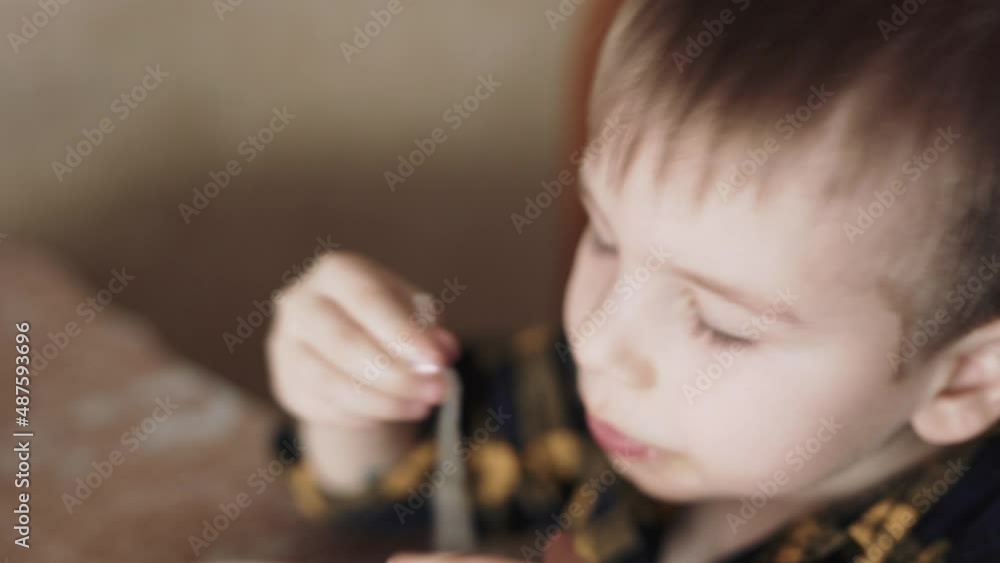 The child eats Chinese noodles with his hands The child eats Chinese noodles with his hands